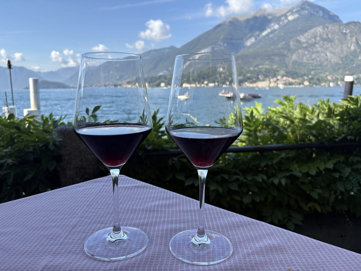 Two red wine glasses in Hotel Florence with a lake front view of Lake Como in Bellagio