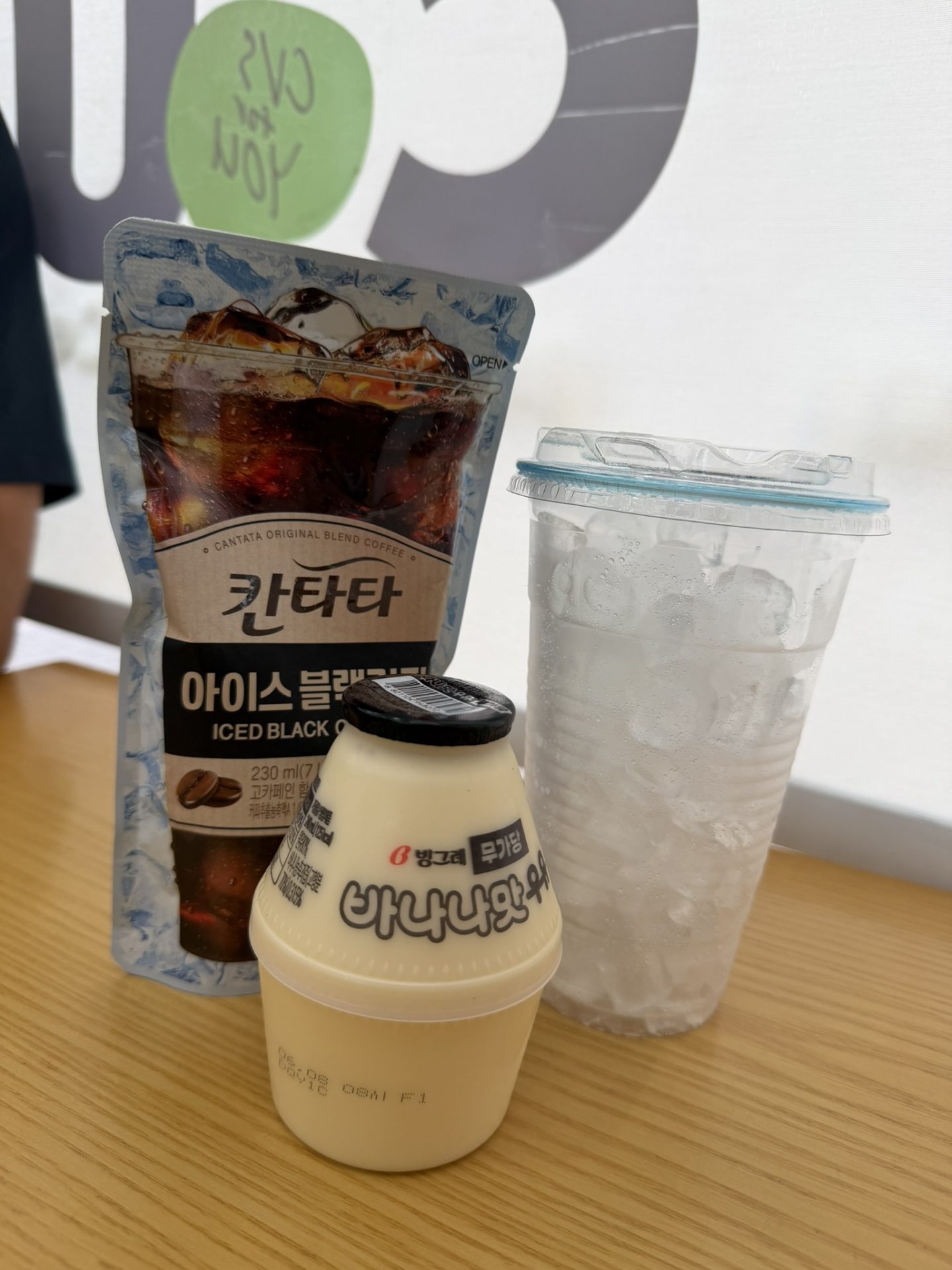 Banana milk, iced coffee pouch and cup of ice from a Korean convenience store