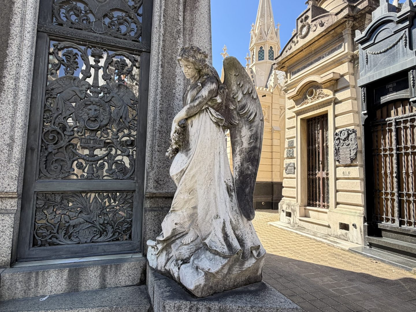 Angel statue beside ornate mausoleums in Recoleta Cemetery, Buenos Aires